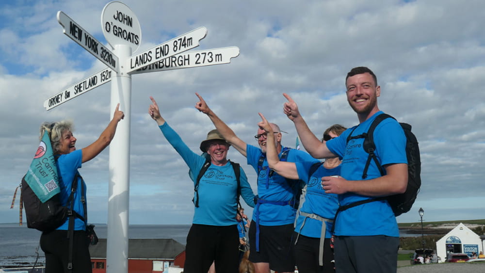 Photograph of John Gibson and fellow walkers reaching John O' Groats