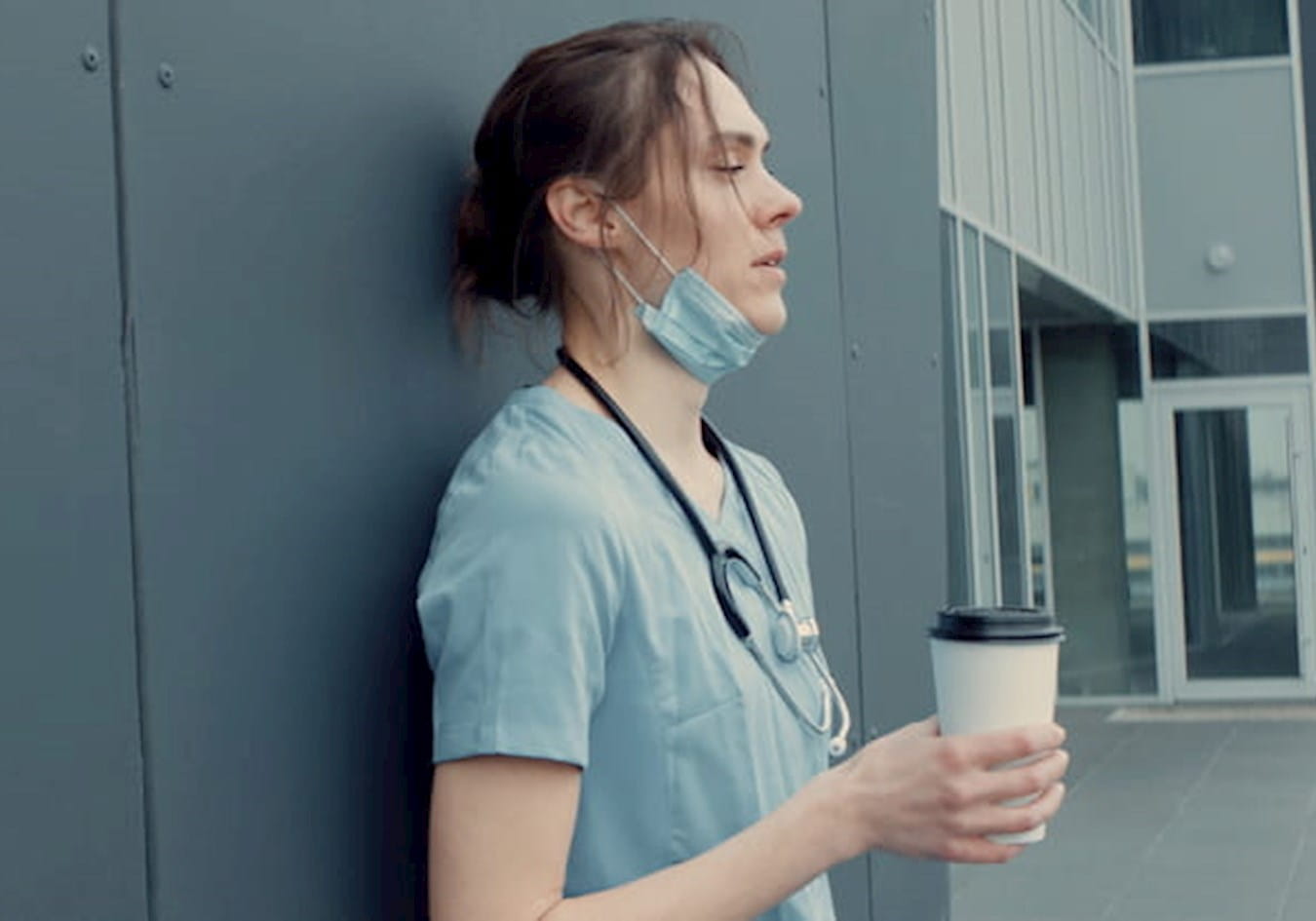 Tired young doctor with coffee cup