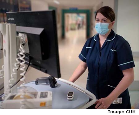 Nurse Emma Cruz standing at computer monitor