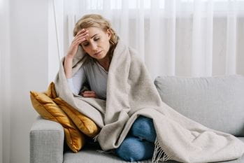 Unwell woman under blanket
