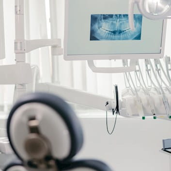 Dental surgery with radiograph displayed on computer screen